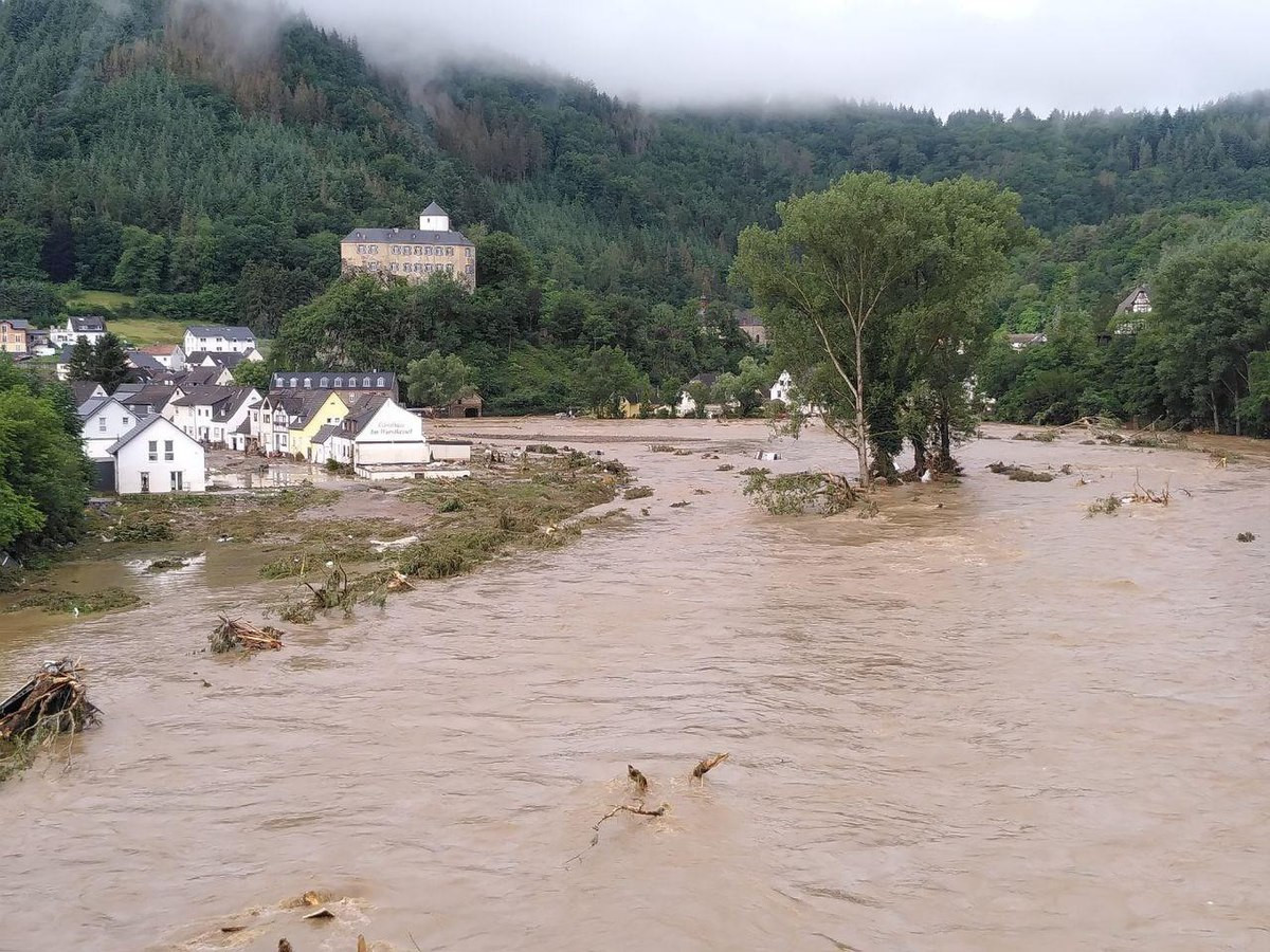 Crue de l'Ahr à Altenahr, en Allemagne, pendant les inondations de juillet 2021. Sur la gauche, des maisons partiellement inondées bordent la rivière. En arrière-plan, une colline recouverte de forêt complète le paysage. © Martin Seifert L’Europe du Nord coincée dans un “blocage oméga”