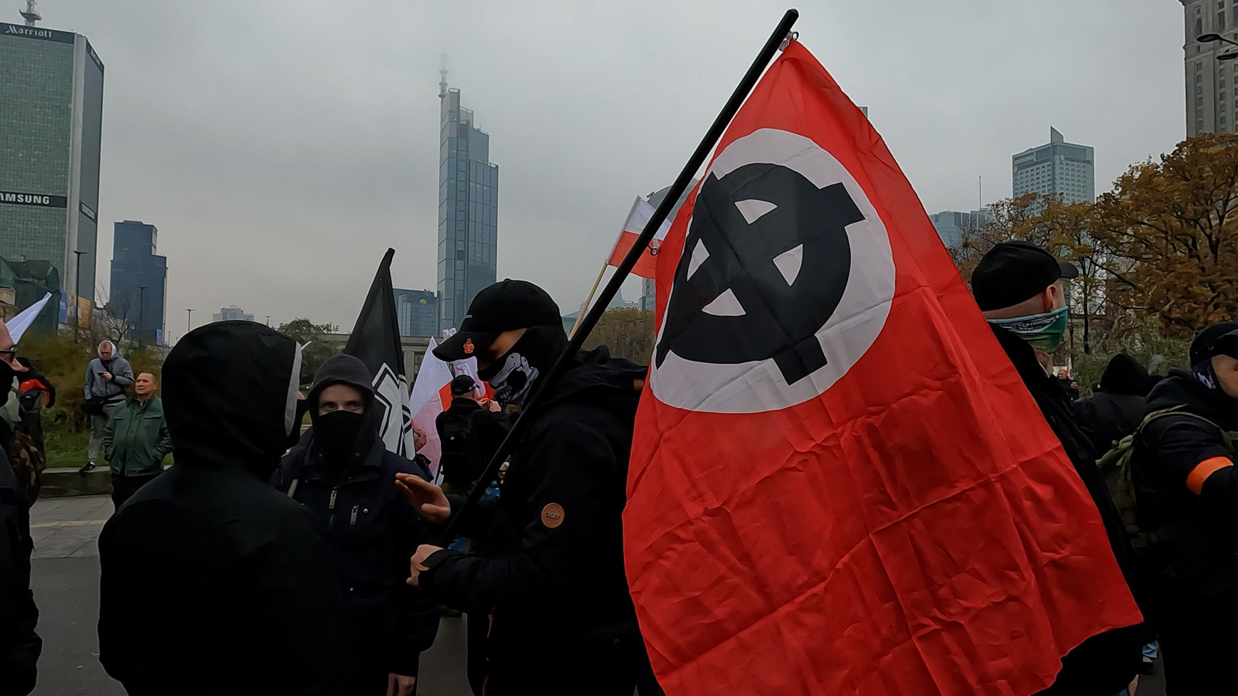 © Wikimedia Commons - Callum Darragh (Manifestation de nationalistes à Varsovie (Pologne) en février 2024, avec des skinheads vêtus de noir brandissant des drapeaux polonais et un drapeau néonazi.) Aux portes du pouvoir : la percée des extrêmes droites en Europe