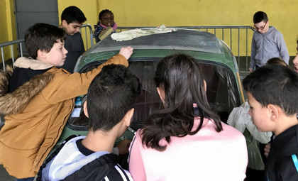 Élèves transportés par une voiture-tableau dans la cour de récré