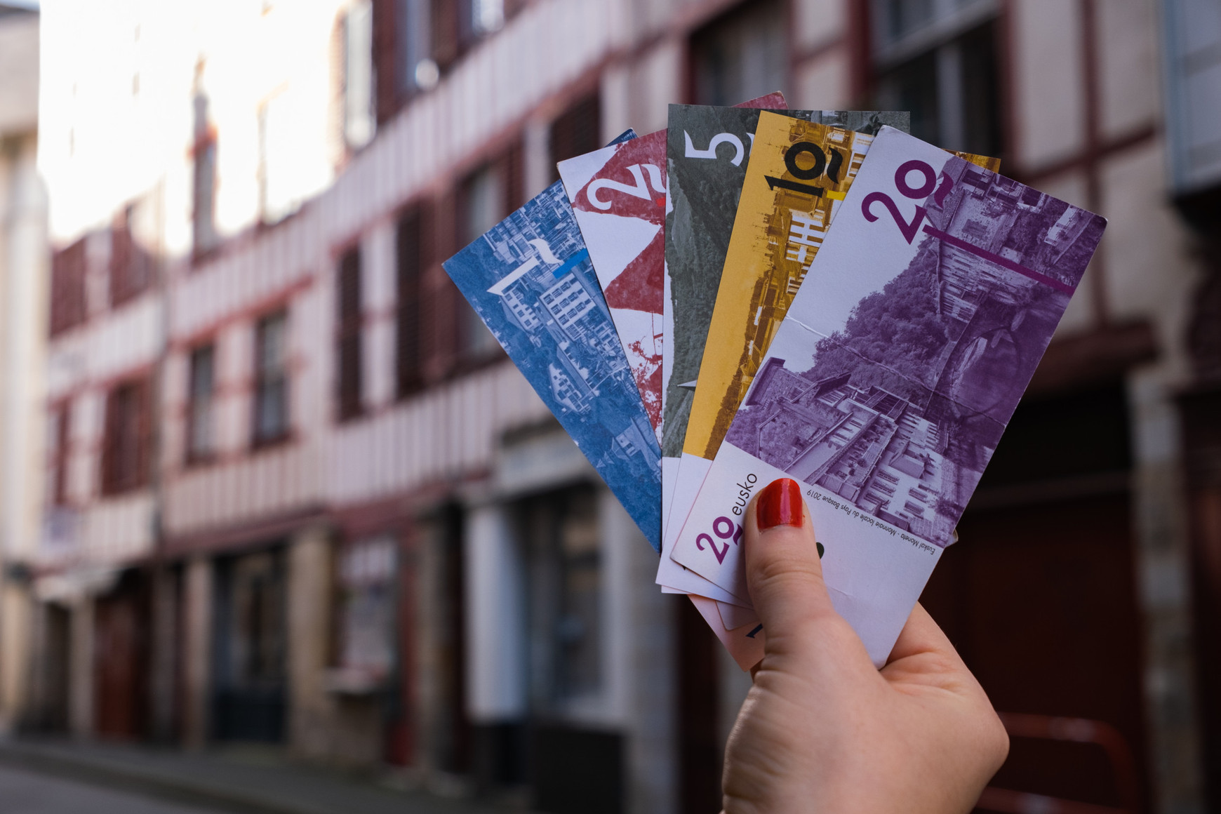 © Laura Monmarin. Les cinq billets eusko (1, 2, 5, 10 et 20) dans les rues de Bayonne. Dante Edme-Sanjurjo raconte l'Eusko, monnaie locale complémentaire Basque