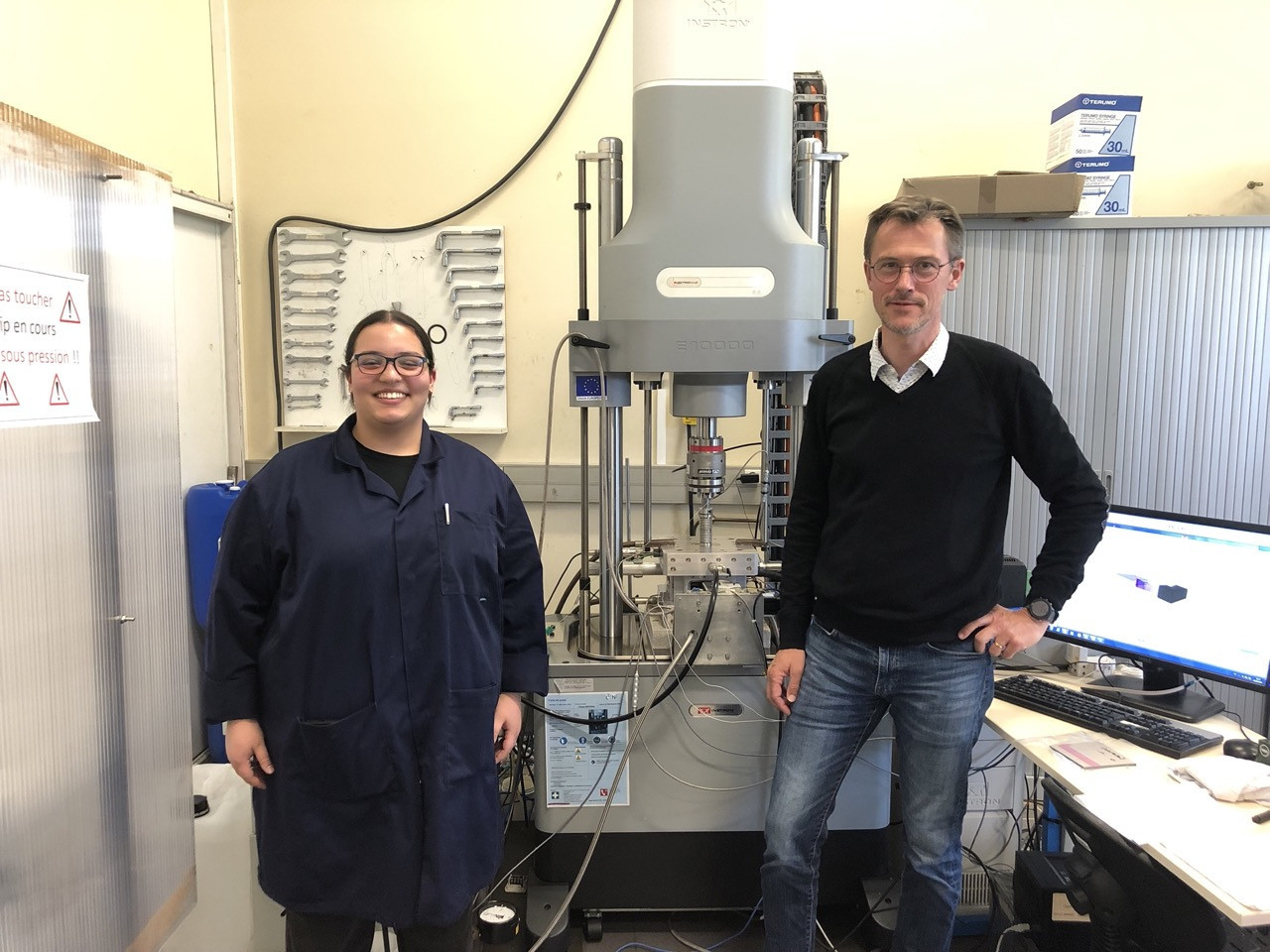 Sourour Traouli et Steven Le Corre devant la machine du laboratoire, composée d'un petit four bardé de capteurs et d'une presse. © Zacharie Gaborit Cette machine unique au monde à Nantes accélère la recherche sur les matériaux composites